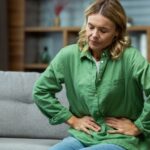 a women holding his stomach and feel stressed