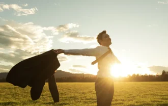Businessman celebrating life standing in green meadow stock photo