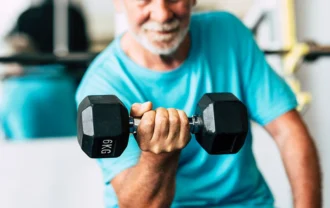 Couple of two happy and fitess seniors doing exercise in the gym together running on the tapis roulant