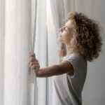 Serene woman waking up and looking out the window